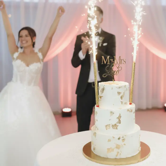 Para młoda świętuje z eleganckim tortem weselnym ze złotymi zdobieniami i racami, przygotowanym przez Pracownię Cukierniczą Torty Złote Iwona Pasternak – Gryfice. Perfekcyjna dostawa, punktualność i tort w idealnym stanie na wesele